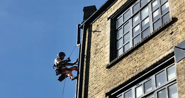 Rope access expert conducting lightning protection system installation on a tall structure